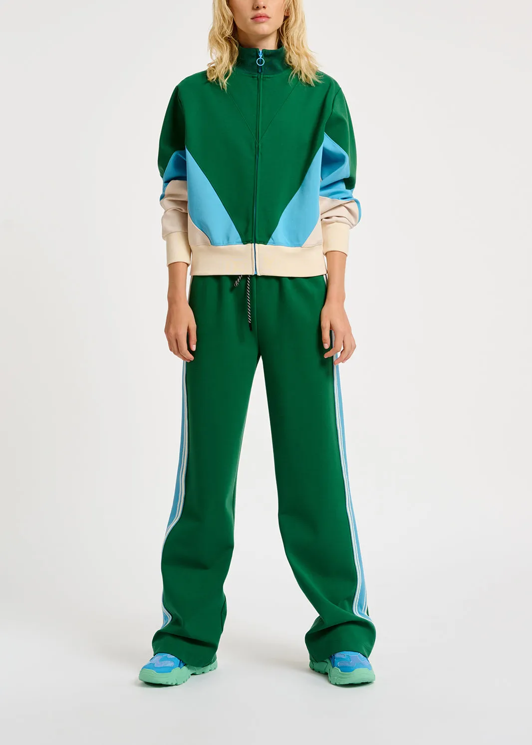 Green track pants with blue and off-white stripes