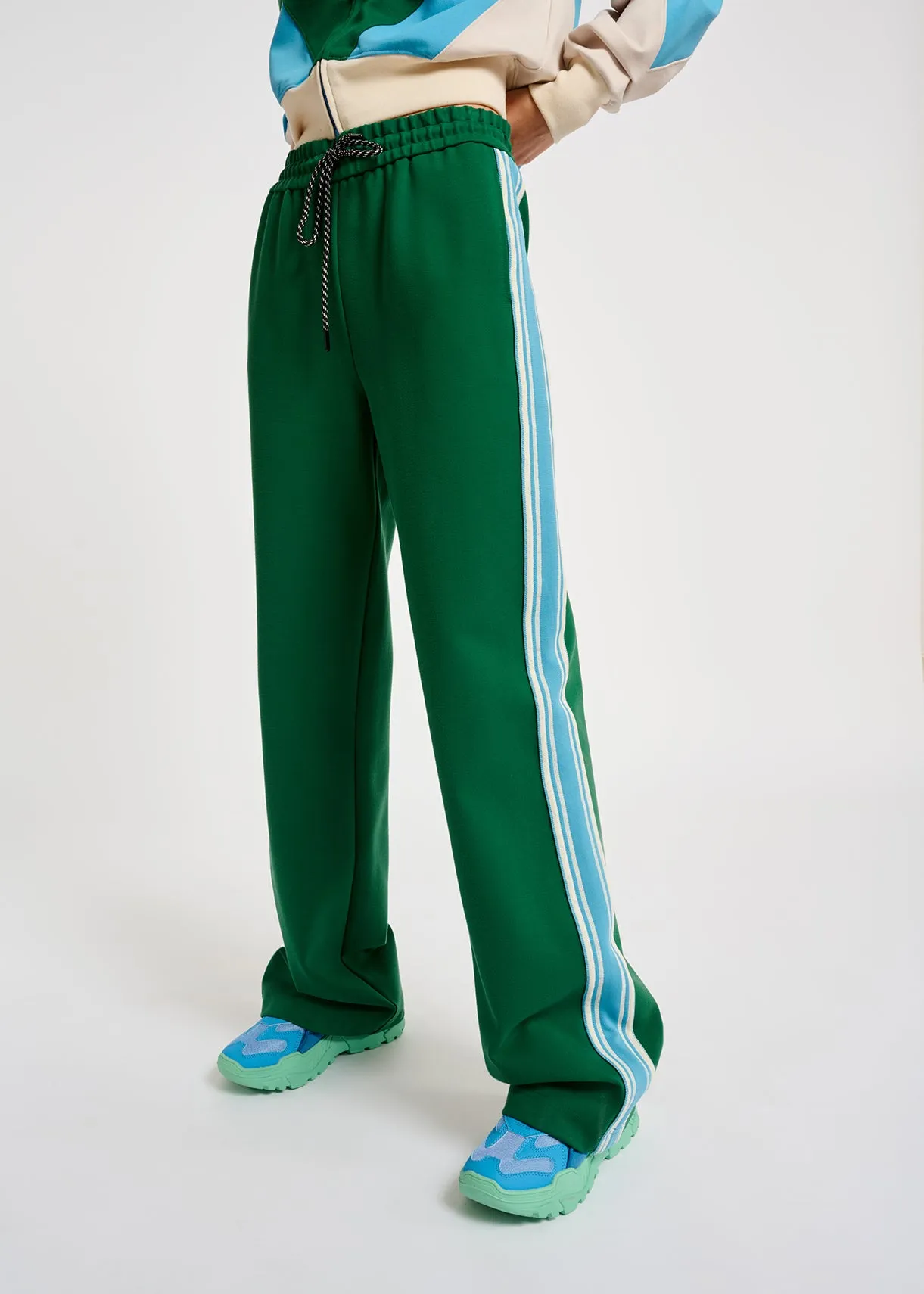 Green track pants with blue and off-white stripes